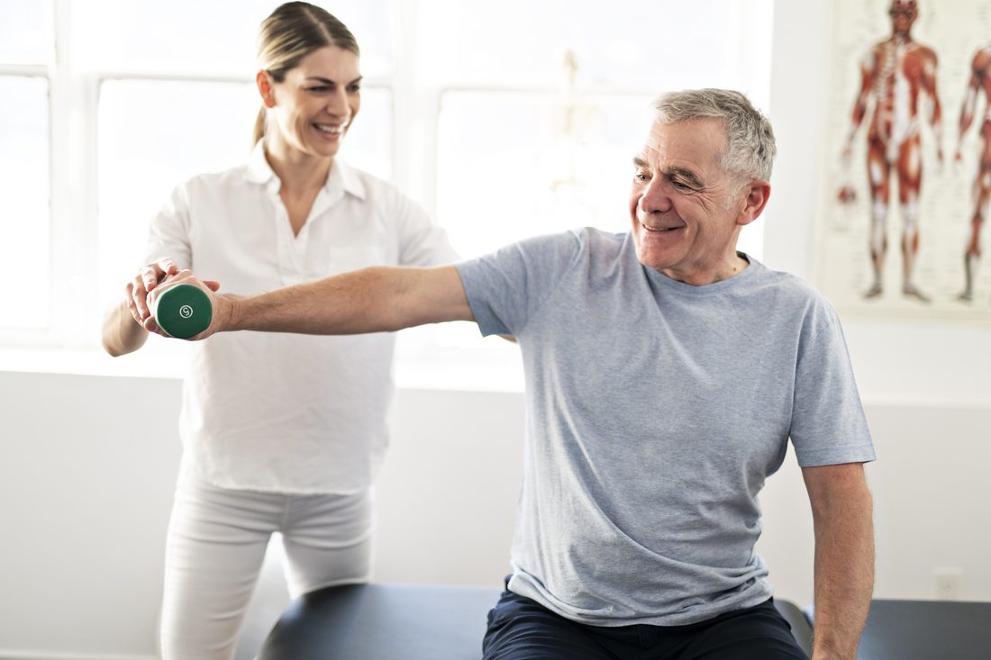 Physical therapist guiding a patient through a shoulder mobility exam in a specialty practice